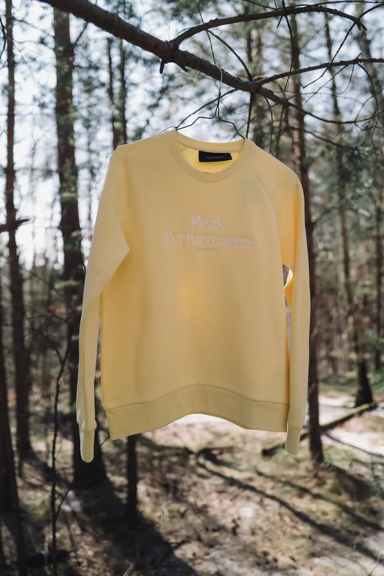 Model in Peak Performance Jacke auf Felsvorsprung im Elbsandsteingebirge – Carsten Beier